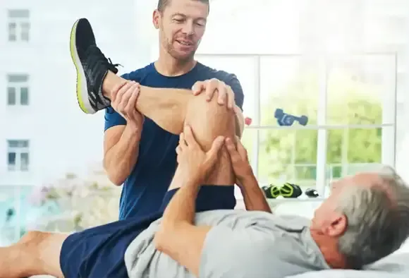 A patient at home with a NICE1 knee wrap during knee replacement recovery